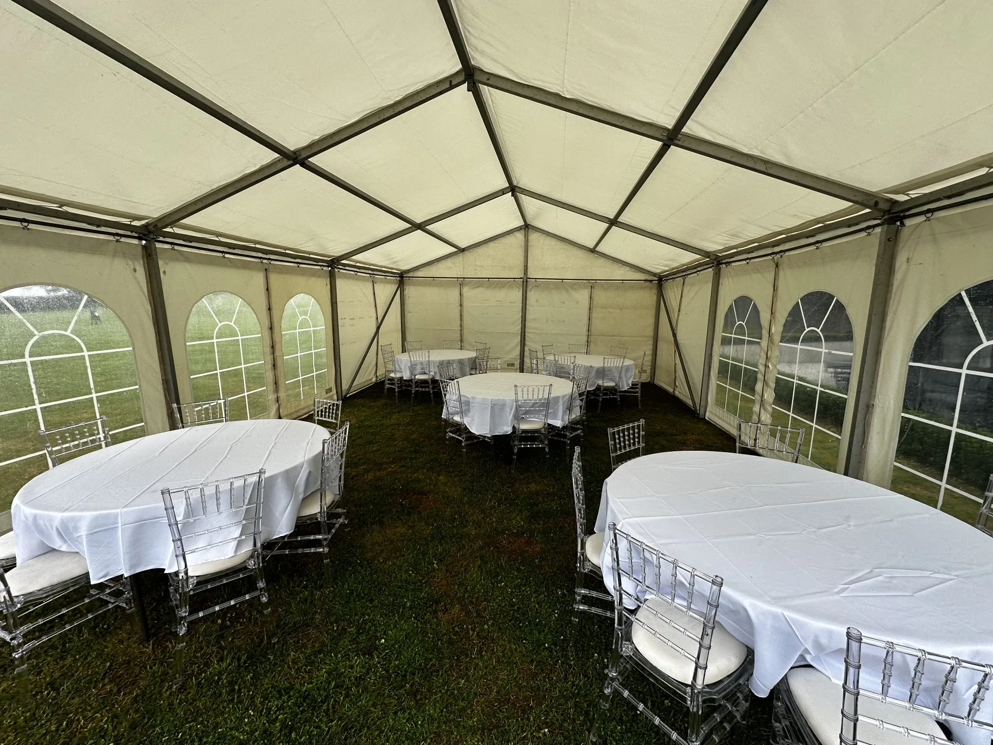White event chairs and round tables inside an SMH marquee